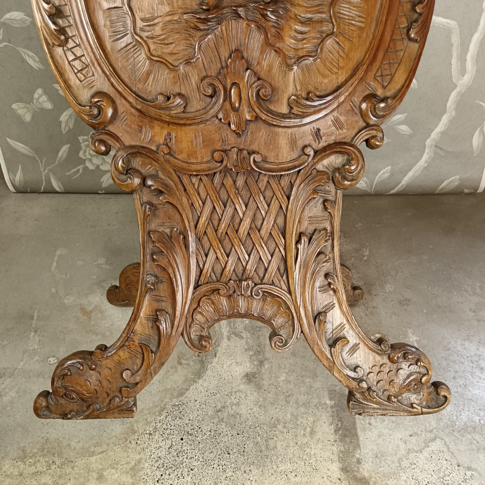 A 19th-century Italian carved walnut pedestal stand featuring a central relief carving of a cherub, acanthus scrollwork, and lattice detailing. View IV