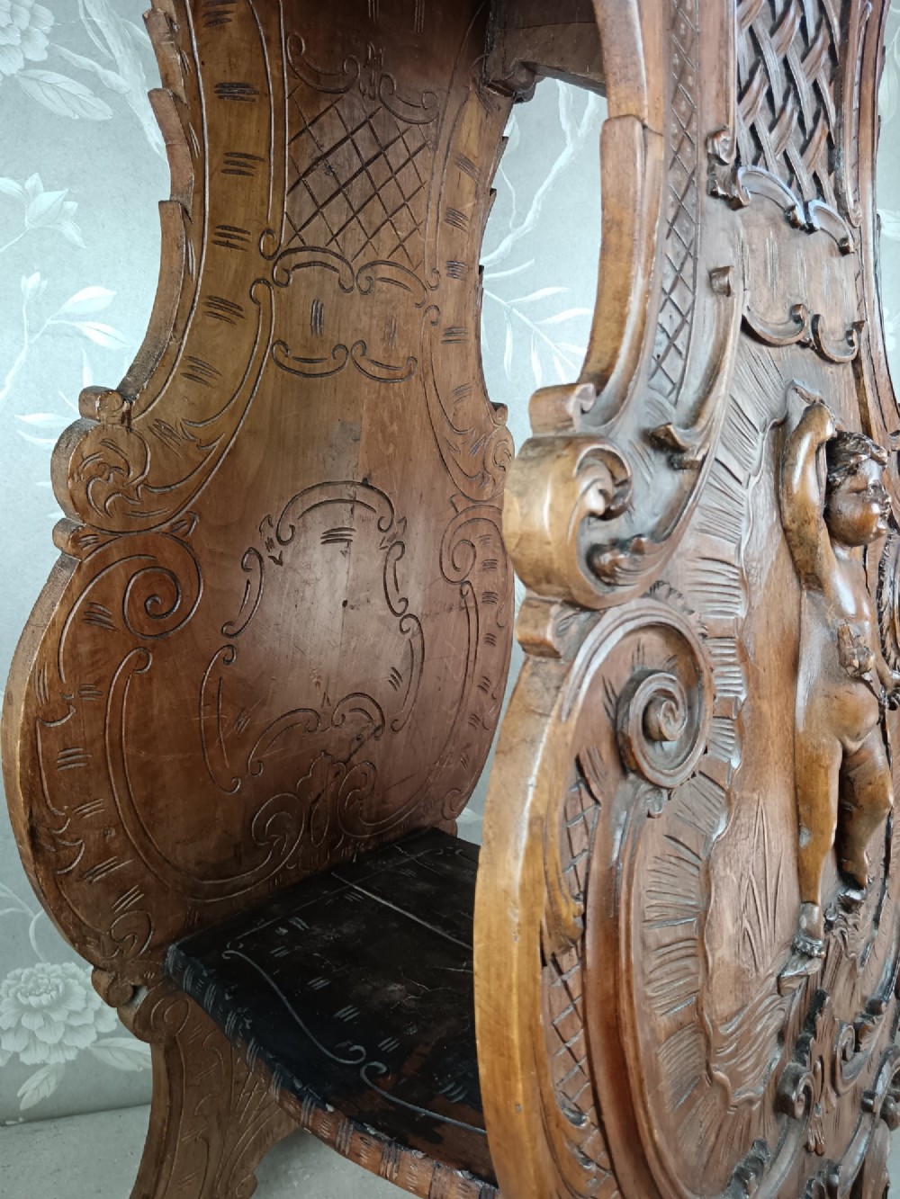 A 19th-century Italian carved walnut pedestal stand featuring a central relief carving of a cherub, acanthus scrollwork, and lattice detailing. View VII