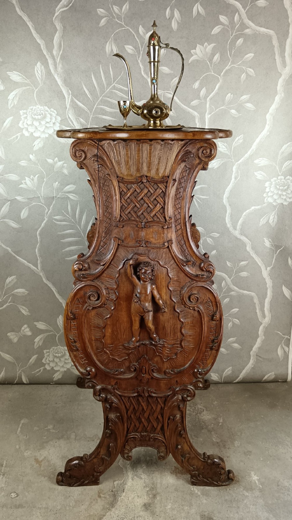 A 19th-century Italian carved walnut pedestal stand featuring a central relief carving of a cherub, acanthus scrollwork, and lattice detailing. View VIII