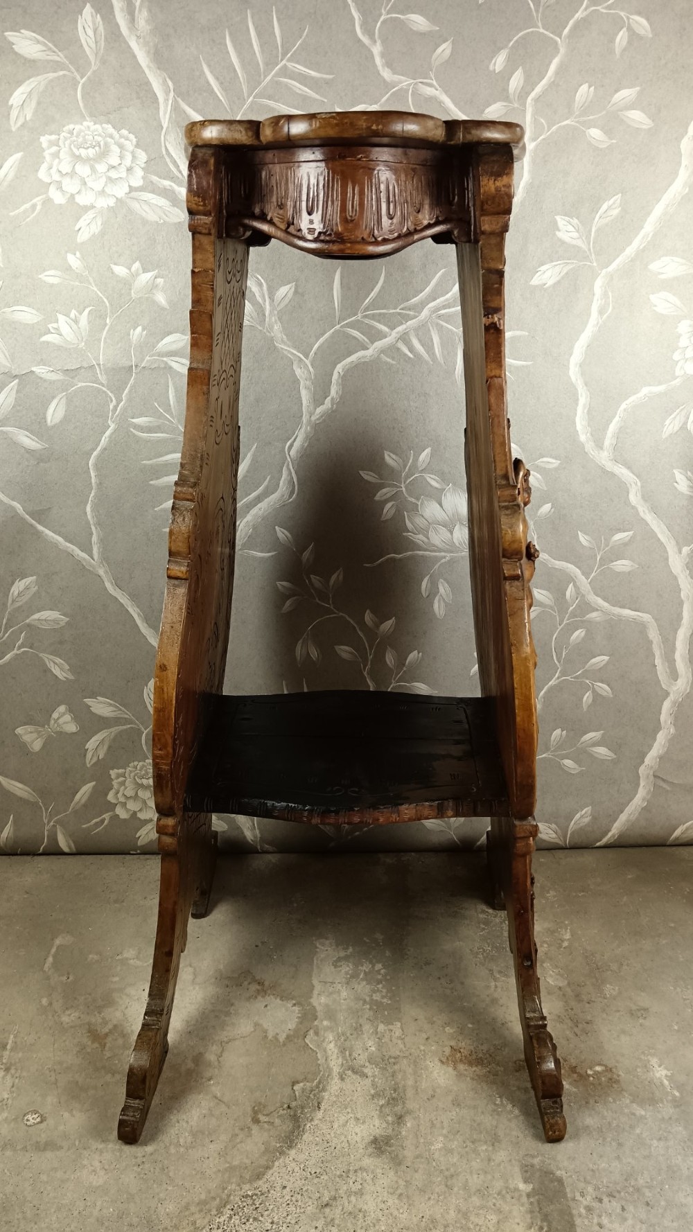 A 19th-century Italian carved walnut pedestal stand featuring a central relief carving of a cherub, acanthus scrollwork, and lattice detailing. View X