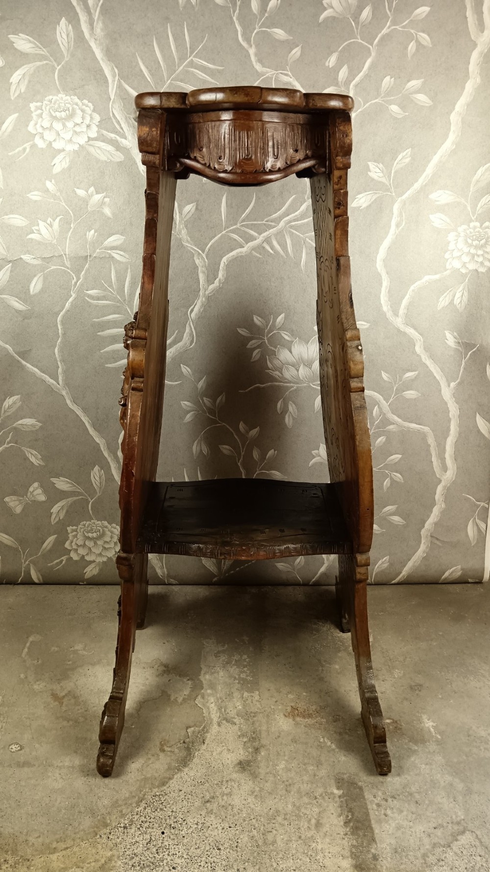 A 19th-century Italian carved walnut pedestal stand featuring a central relief carving of a cherub, acanthus scrollwork, and lattice detailing. View XI