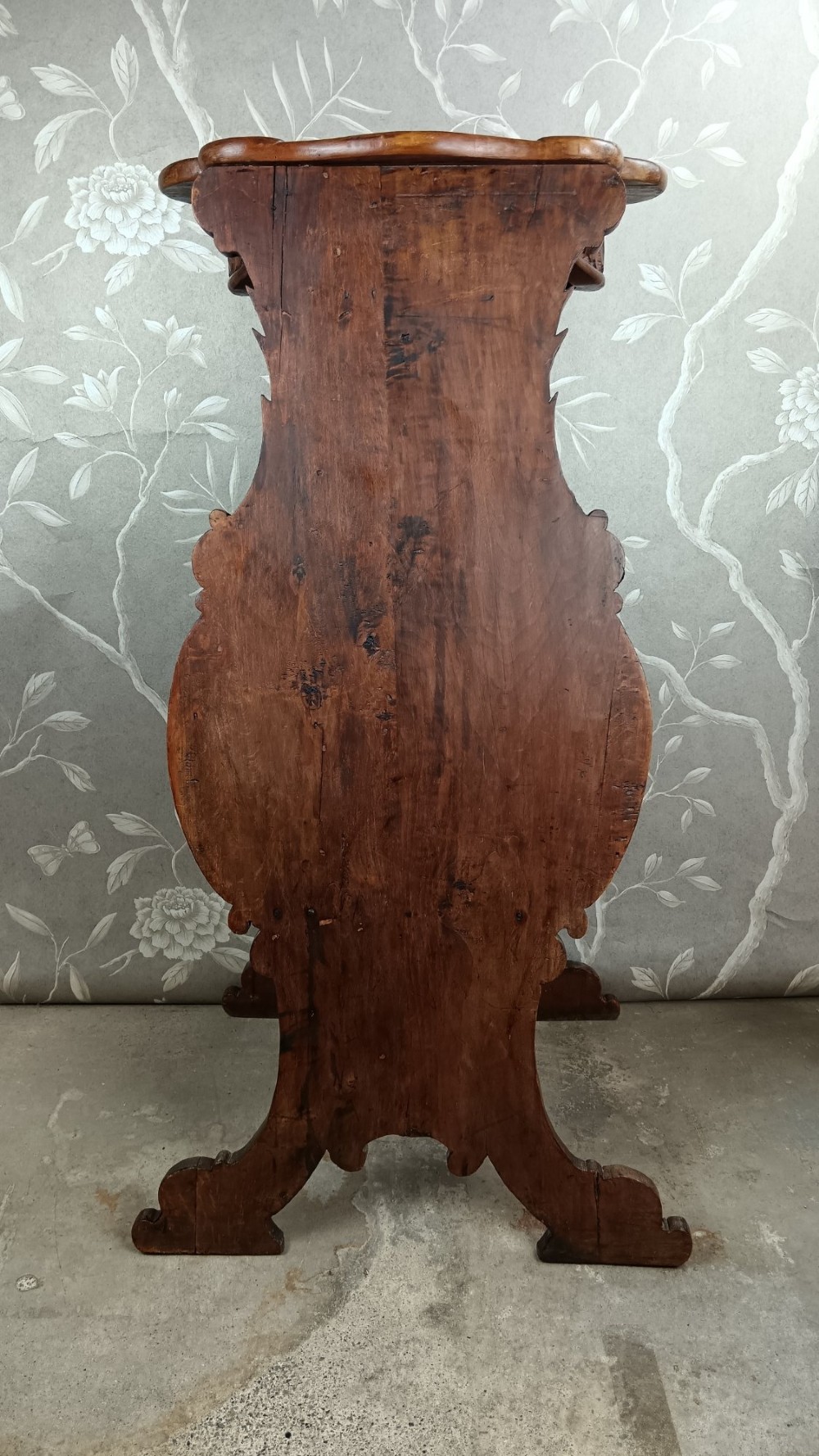 A 19th-century Italian carved walnut pedestal stand featuring a central relief carving of a cherub, acanthus scrollwork, and lattice detailing. View XIII