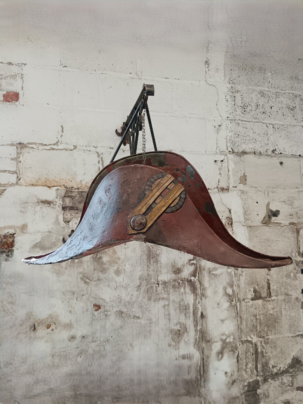 A nineteenth-century painted toleware trade sign shaped in the form of a military bicorn hat with gilt detailing. View III