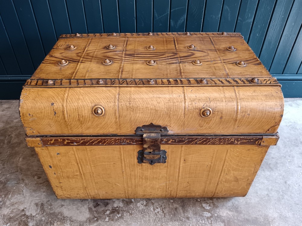 A late nineteenth-century metal steamer trunk featuring a hand-painted faux wood grain finish, dark metal banding, studs, and a central latch. View XIV