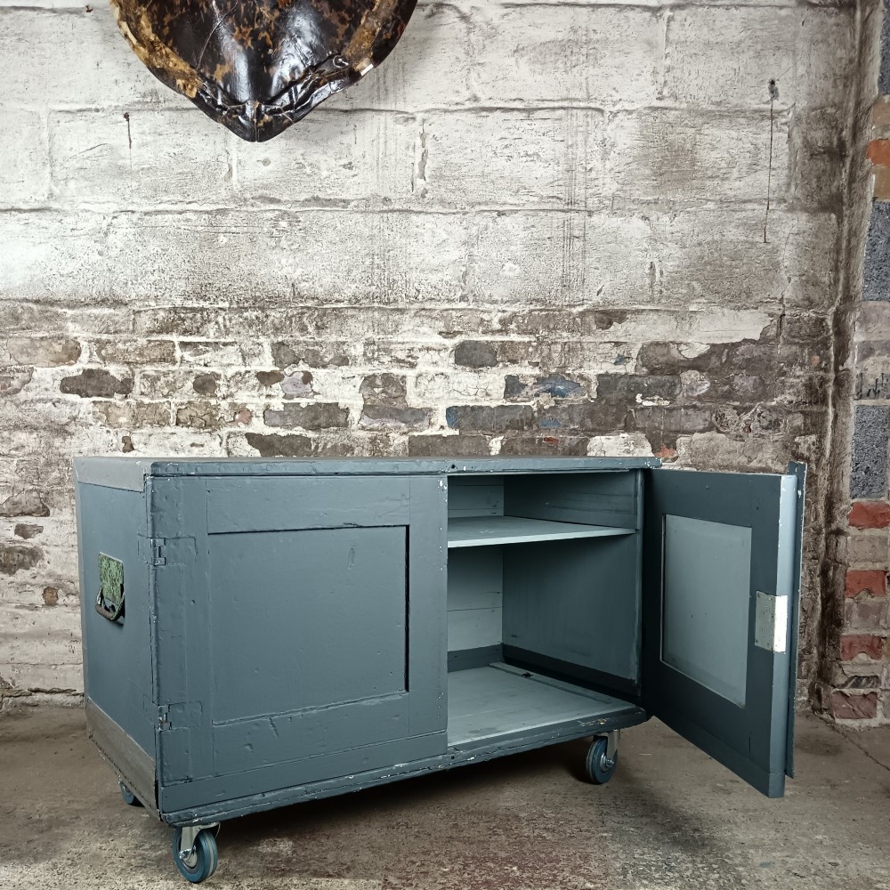 A slate grey painted 19th-century military campaign packing chest with iron flush handles, corner reinforcements, hinged doors, and an internal shelf.