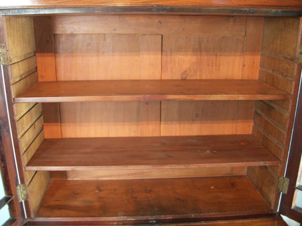 A Regency mahogany secretaire cabinet featuring a triangular pediment top, glazed upper doors, a fall-front desk section, and three drawers below on turned feet. View XIII