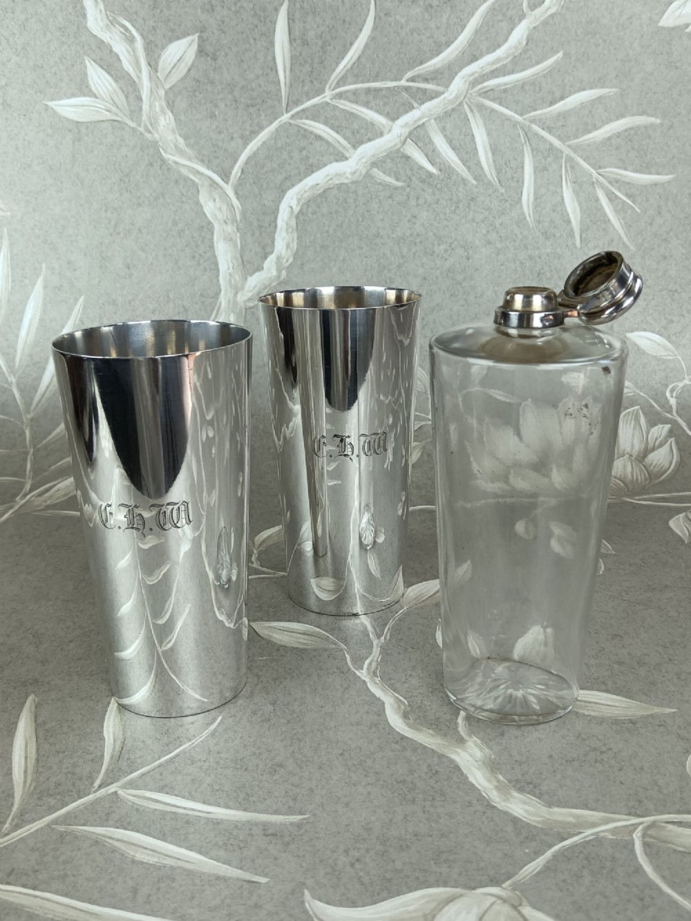 A Victorian leather campaign case with a shoulder strap alongside a glass flask and two silver-plated nesting beaker cups. View V