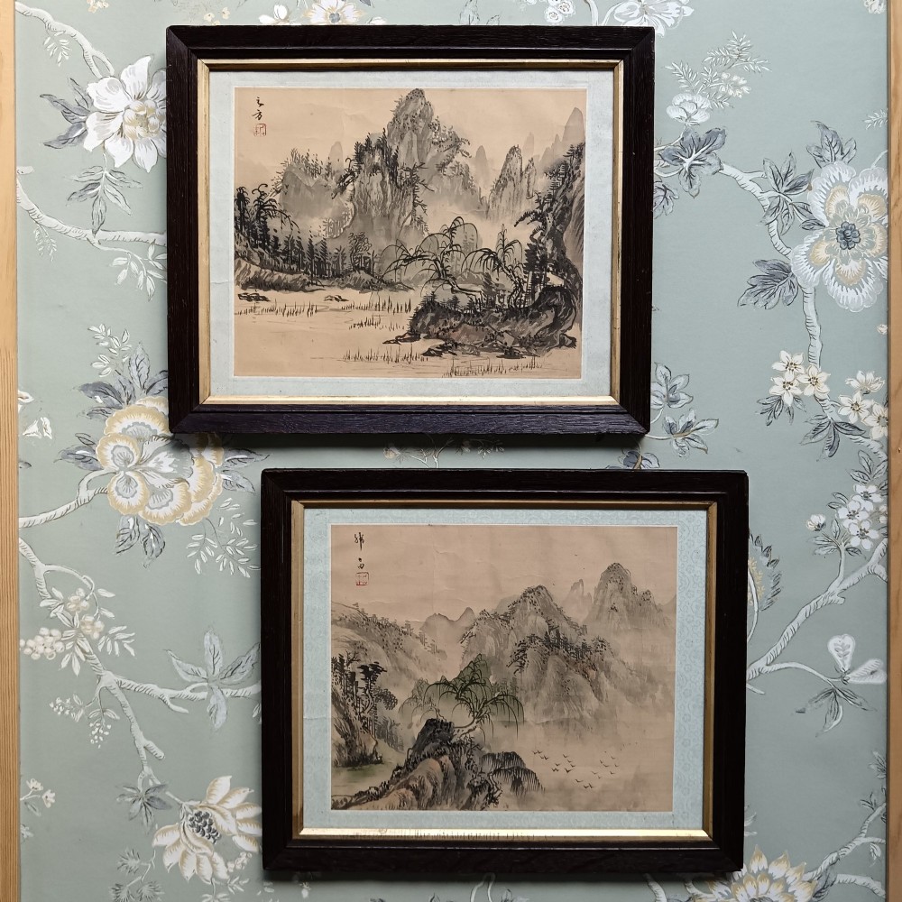 A pair of framed Chinese Shan Shui ink landscape paintings on silk depicting mountainous scenes and trees, presented in dark timber frames with gilded inner trims.