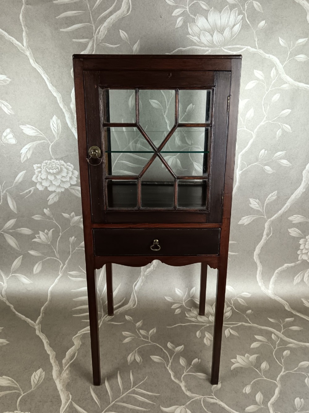 A Georgian mahogany vitrine cabinet featuring glazed side panels, a single lower drawer, straight tapered legs, and a glazed front door with geometric astragal glazing bars. View VIII