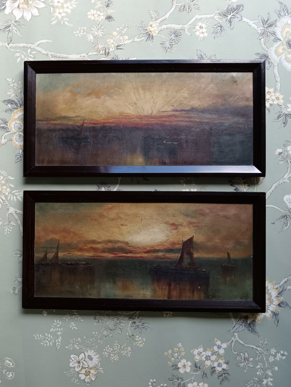 A pair of framed horizontal Edwardian oil paintings depicting atmospheric maritime scenes with sailboats at sunrise and sunset. View II