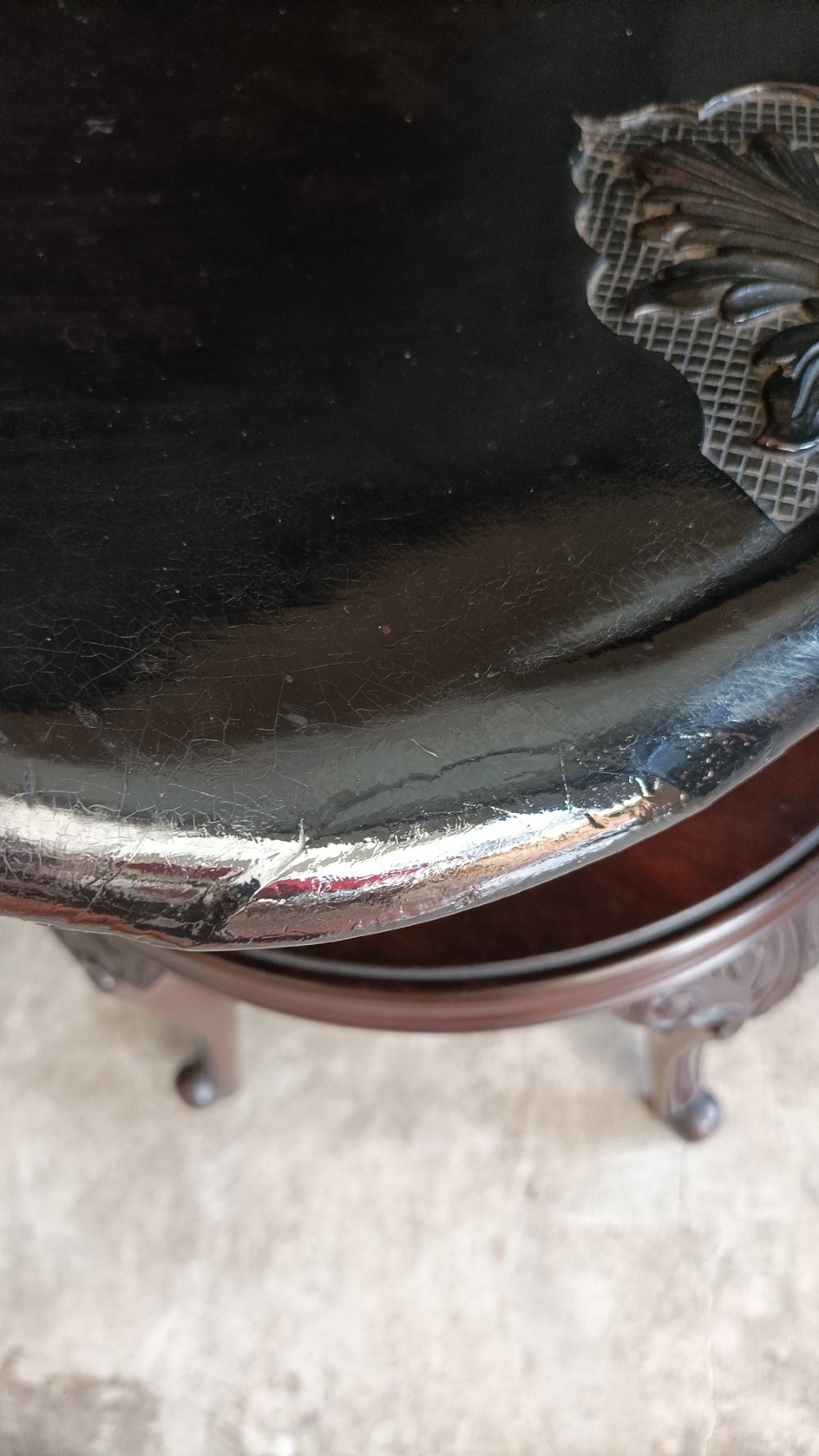 A Victorian mahogany revolving music stool with a scalloped shell-shaped black backrest, turned central pedestal, and four carved legs. View XII