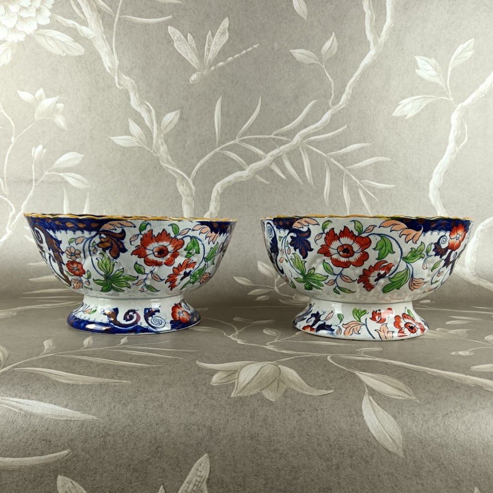 A pair of 19th-century Minton ironstone pedestal bowls with scalloped rims and vibrant Amherst Japan floral transfer pattern in cobalt blue, orange, and green. View V