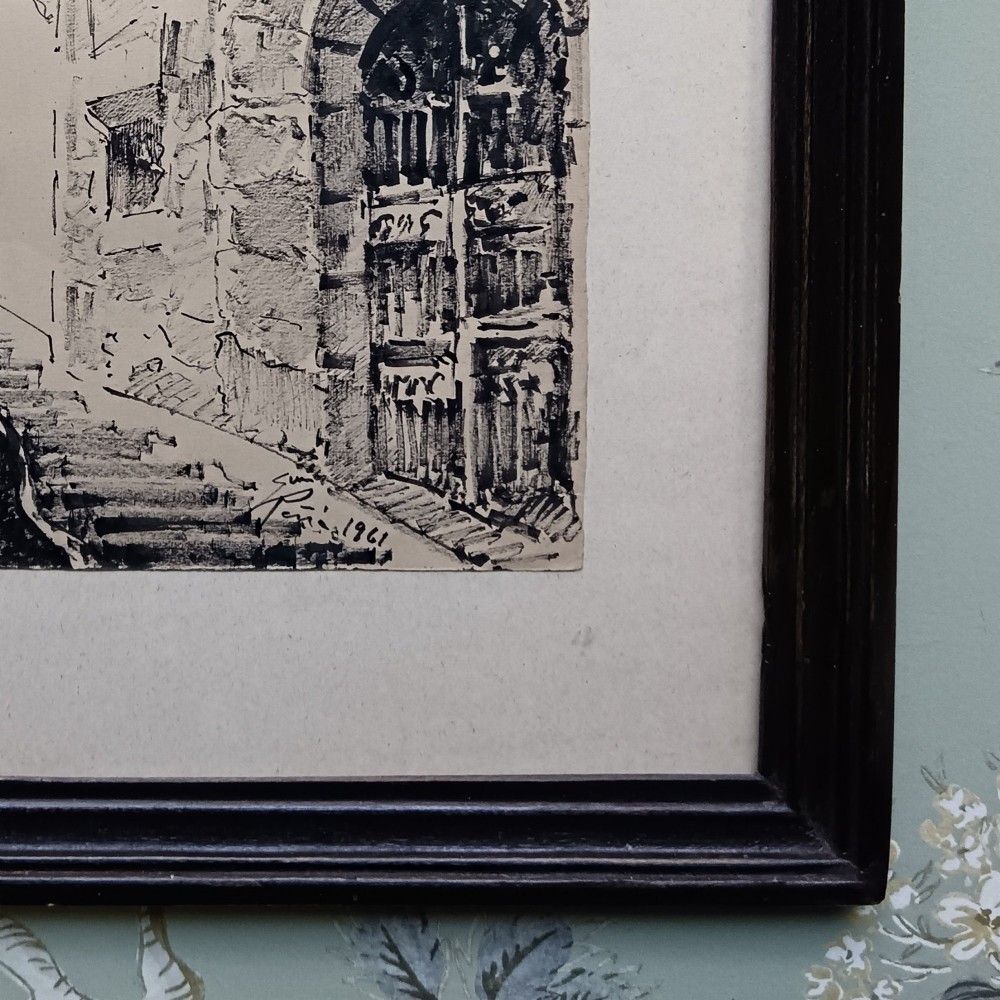 A pair of framed mid-century black ink architectural drawings depicting narrow Spanish street scenes mounted in dark wooden frames. View IV
