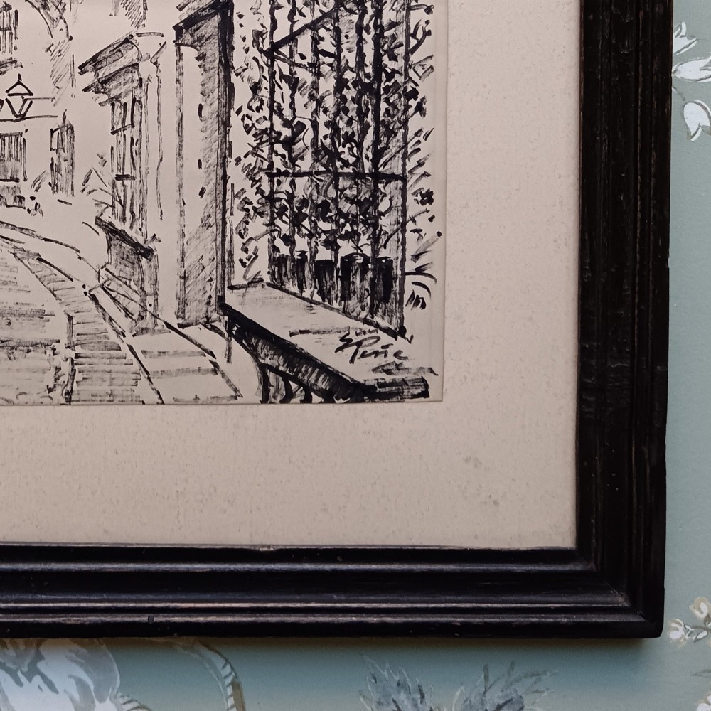 A pair of framed mid-century black ink architectural drawings depicting narrow Spanish street scenes mounted in dark wooden frames. View V