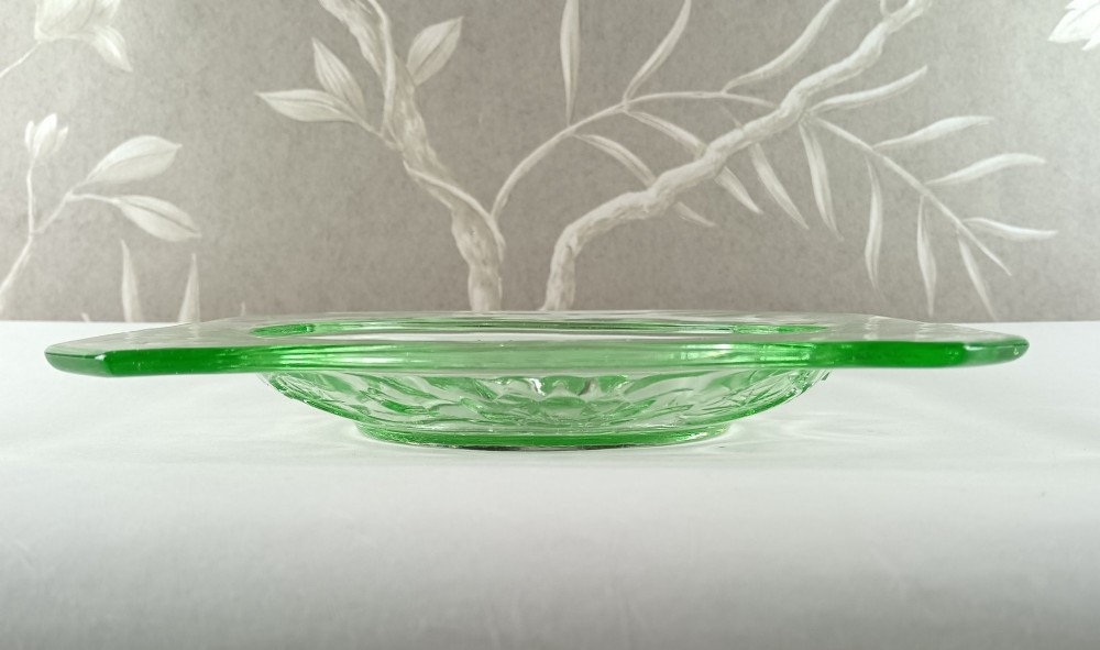 A square pale green Art Deco pressed glass plate featuring a central circular design of two swimming fish surrounded by embossed water lilies. View V