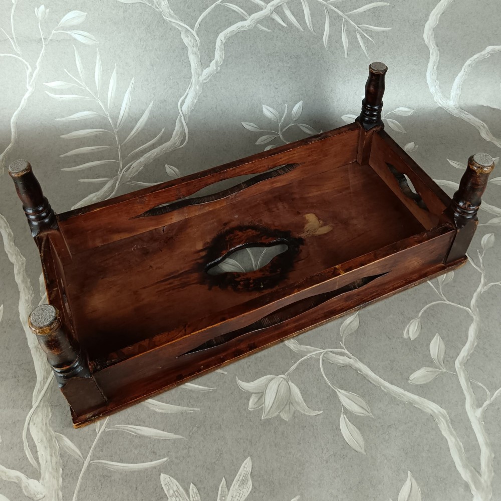A low 19th-century dark brown wooden footstool with turned legs, side cutouts, and a central carry handle slot on the top surface. View VIII