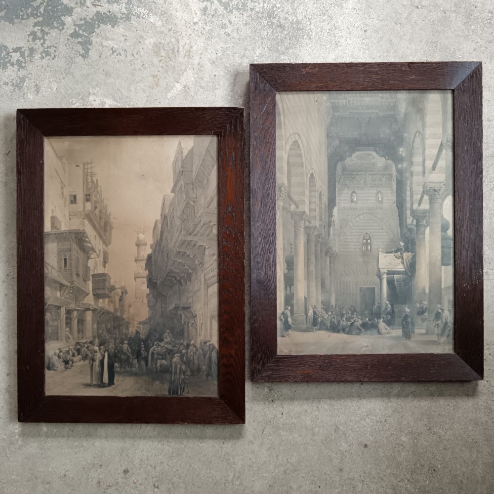 A pair of 19th-century framed lithographs depicting architectural views of Cairo in dark stained oak frames.