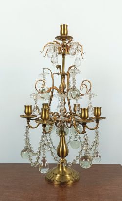 A LOUIS XVI STYLE BRASS AND GLASS SIX ARMED CANDELABRA