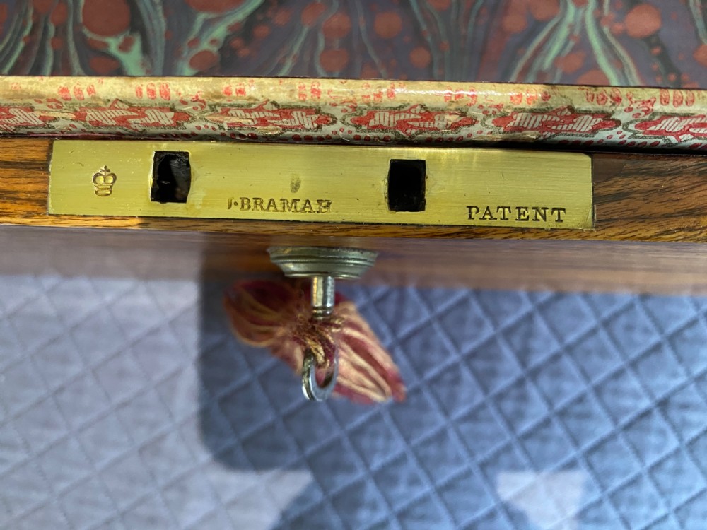 An open Georgian mahogany box featuring a polished timber grain exterior, a brass lock with key, and an interior lined with green marbled paper. View III