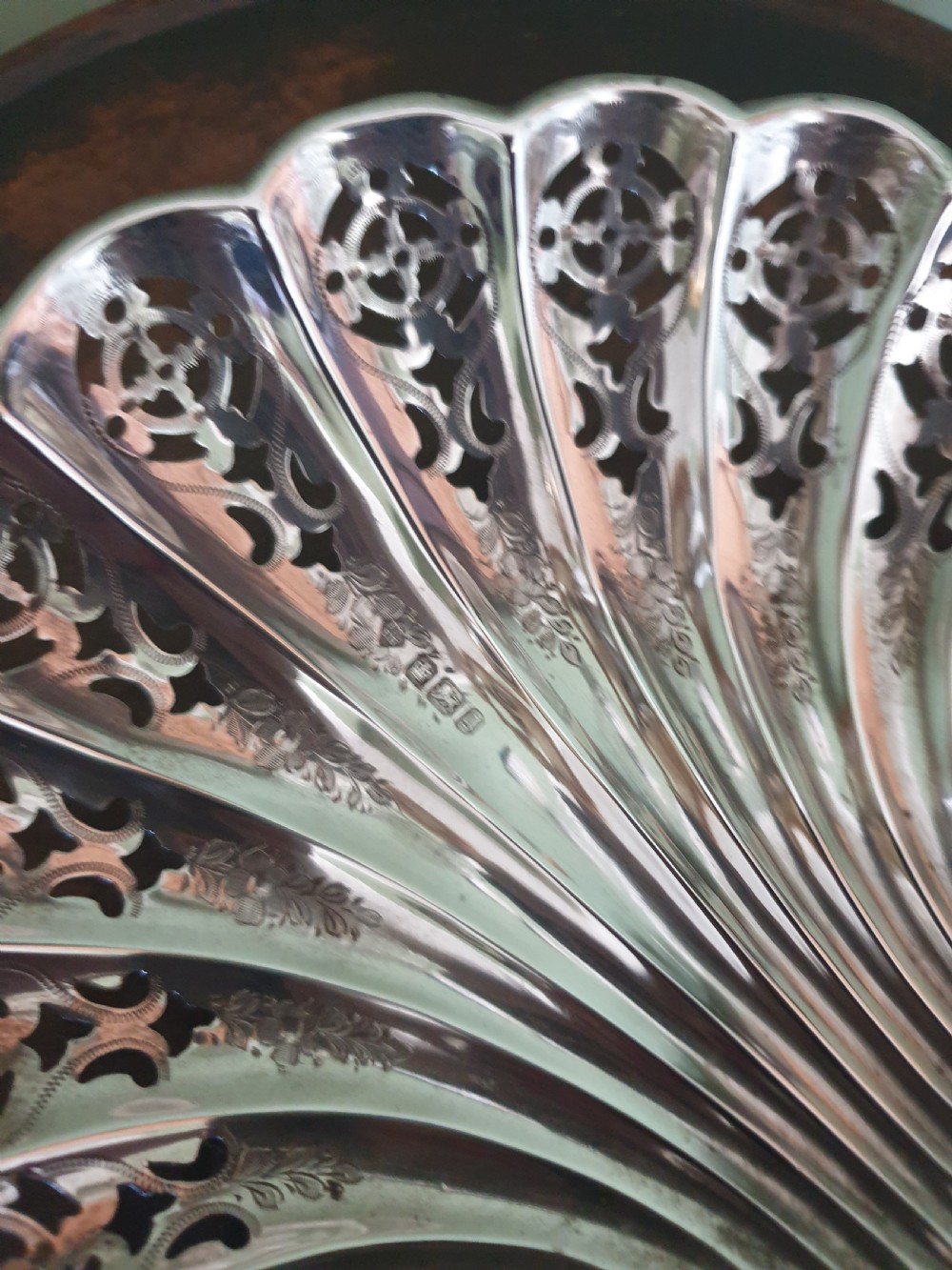 An antique sterling silver dish shaped like a scallop shell featuring intricate pierced lattice work and engraved details, hallmarked in Sheffield 1900. View II