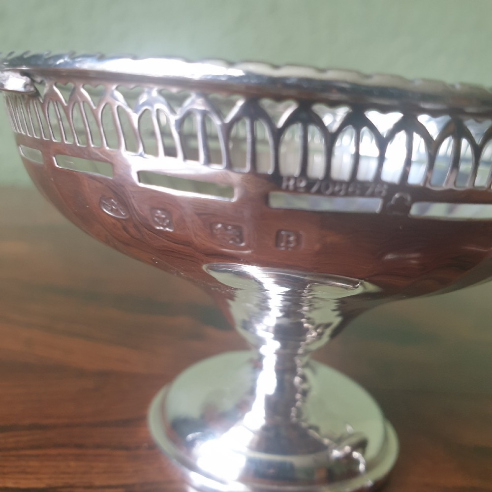 A pair of sterling silver tazzas featuring fluted bowls, pierced geometric rims, twin handles, and circular pedestal feet. View III