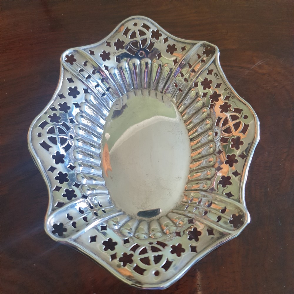 An Edwardian silver dish featuring pierced fretwork motifs along the rim and a fluted central well. View II