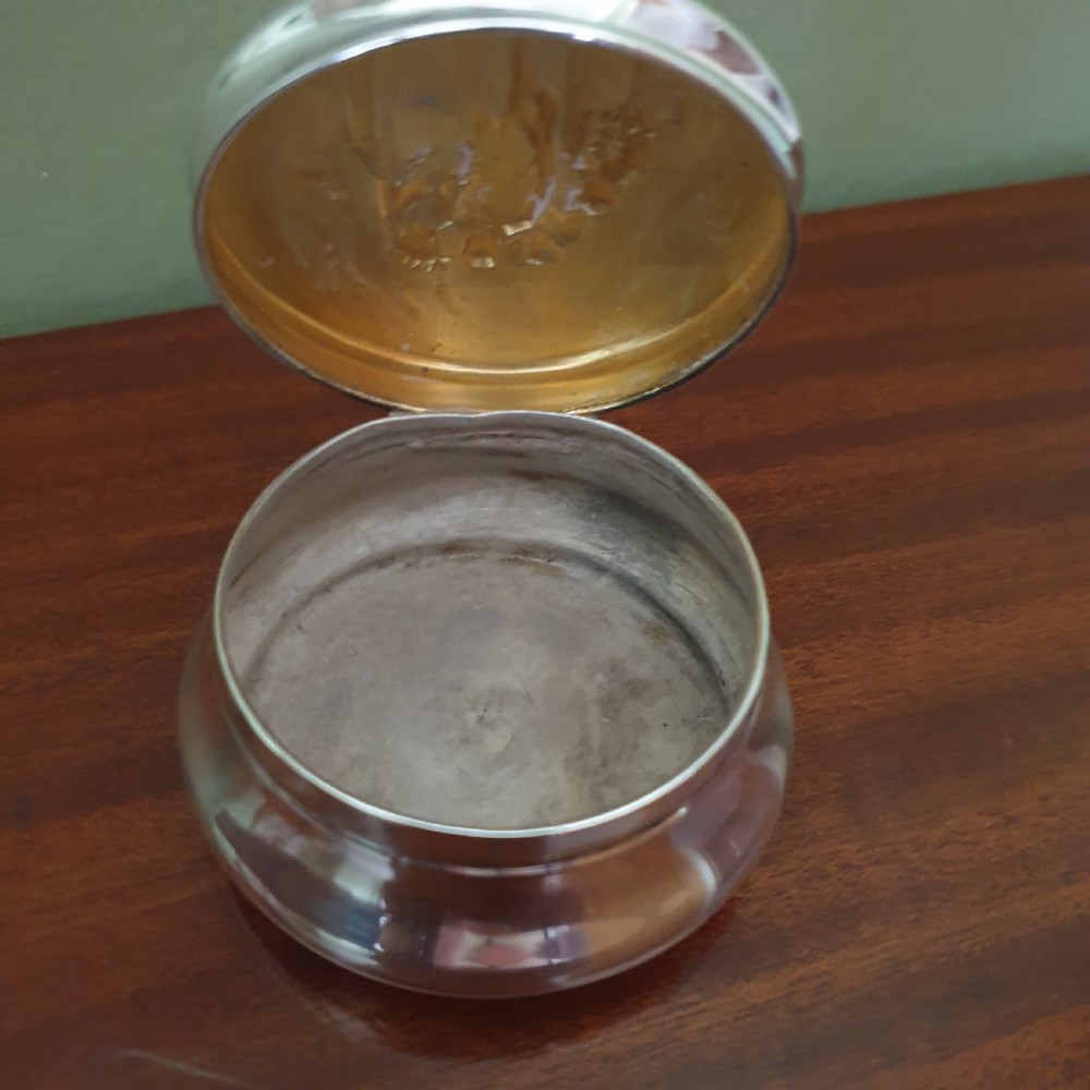 A circular Edwardian sterling silver pot lid featuring embossed figures and official London hallmarks. View III