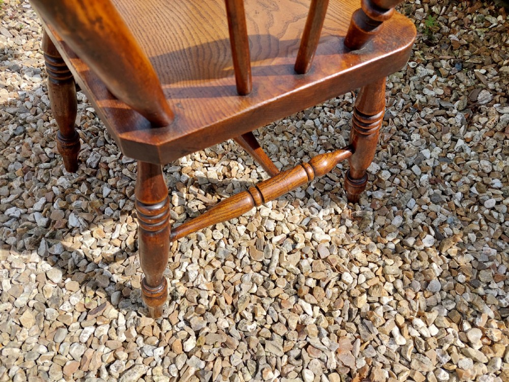A 19th-century wooden lath back Windsor armchair with turned legs, curved armrests, and a contoured solid wood seat. View V