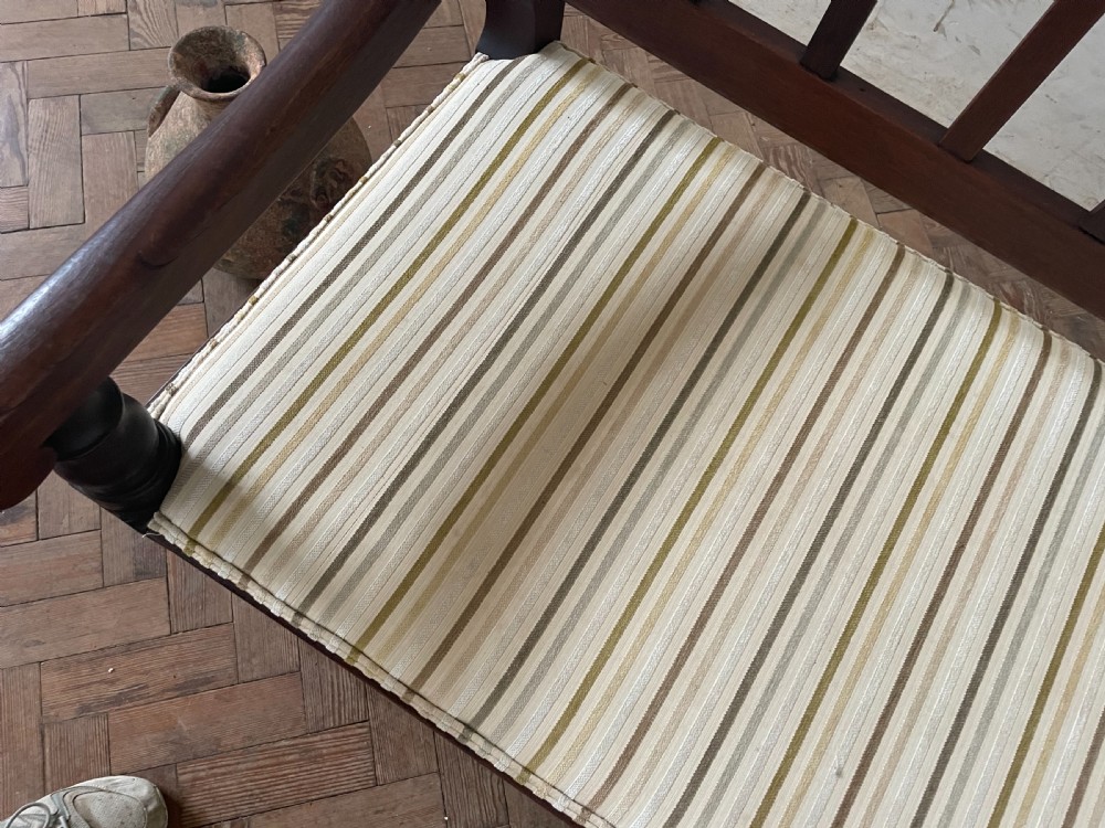 A dark wood hallway bench featuring a scalloped top rail, a slatted backrest, turned legs, and a striped fabric seat cushion. View II
