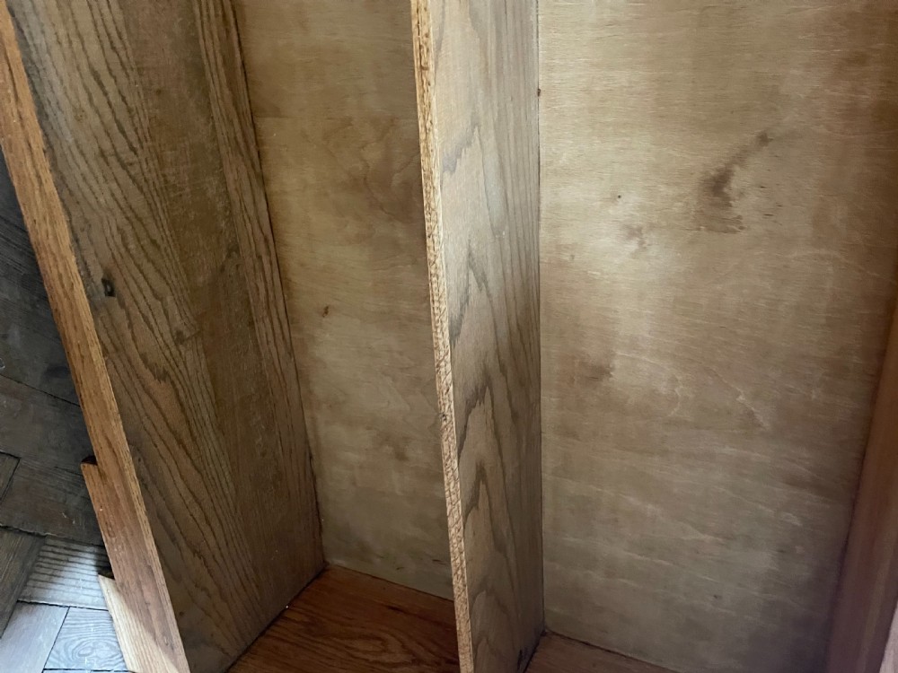 An Art Deco oak cabinet featuring two upper leaded glass doors over two solid wood panel doors with a stepped top crest. View VIII