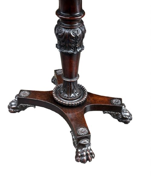 fig 1. An antique 19th-century Regency rosewood tea poy featuring an octagonal hinged top, carved acanthus column, and quadform base with lion paw feet.
