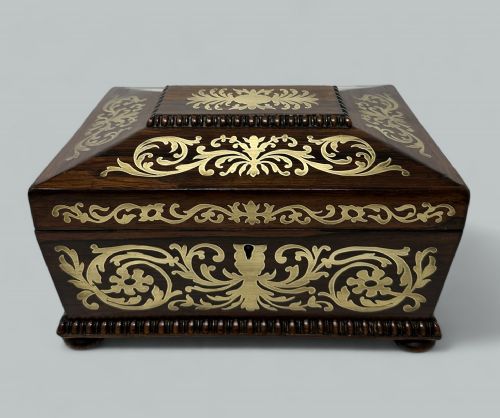 fig 1. An antique dark rosewood rectangular casket featuring detailed brass scrollwork inlay and gadrooned wood edging.