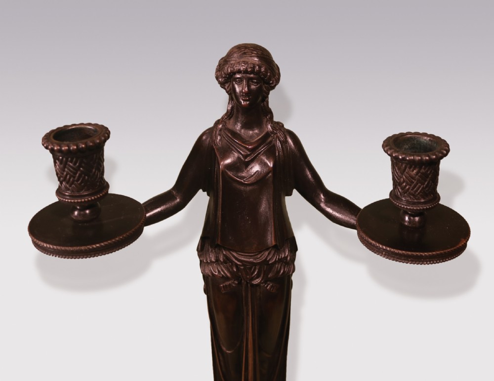 A pair of patinated bronze female caryatid candelabra holding two sconces each, mounted on tall rectangular yellow marble bases. View II