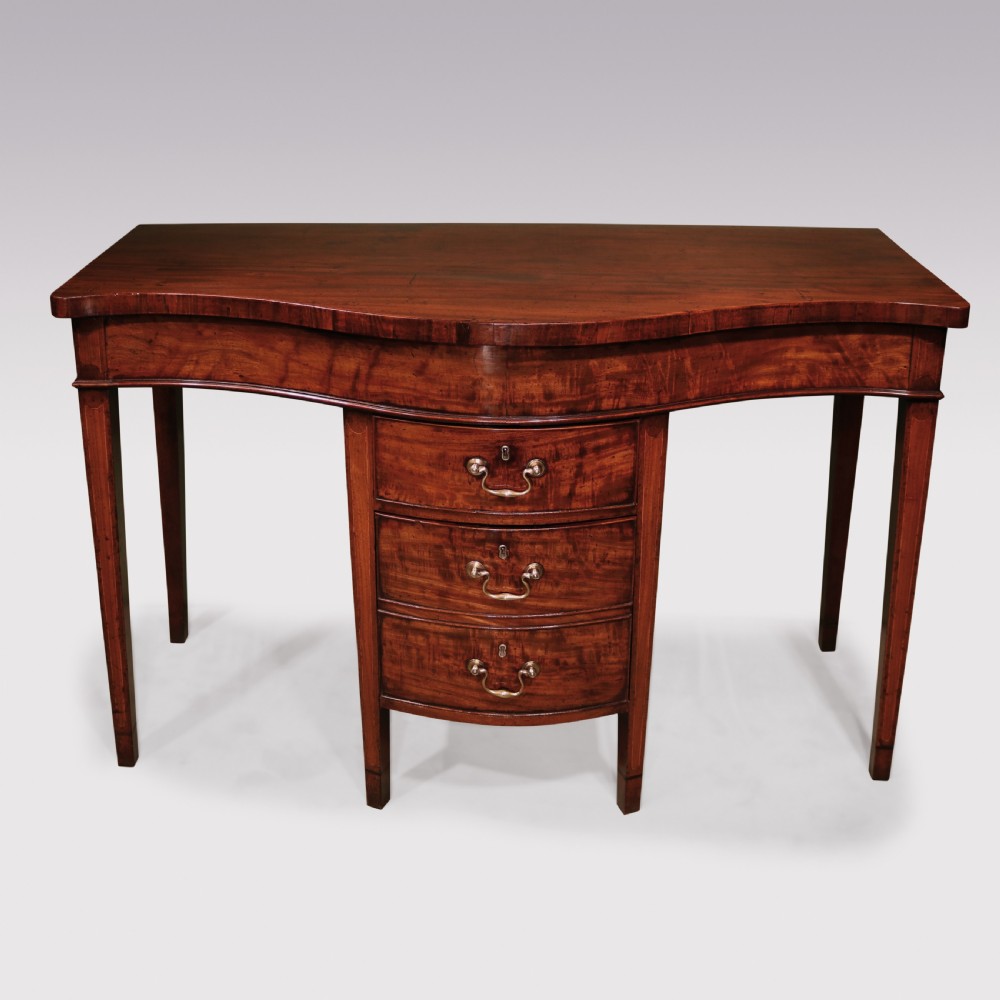 A George III period mahogany serving table featuring a curved front, central drawer stack with brass swan-neck handles, and tapered square legs.