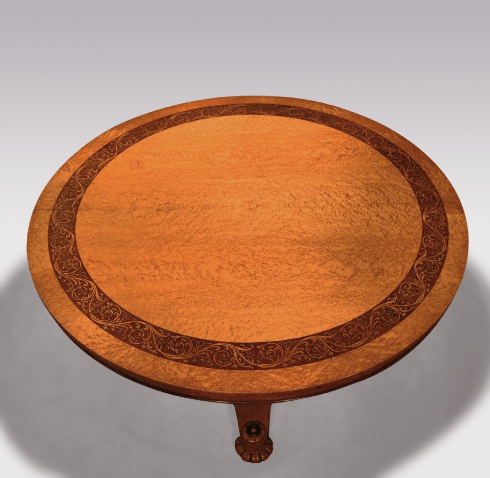 A circular mid-19th-century centre table crafted from birdseye maple featuring an inlaid decorative border, a carved baluster pedestal, and a platform base on carved feet. View II