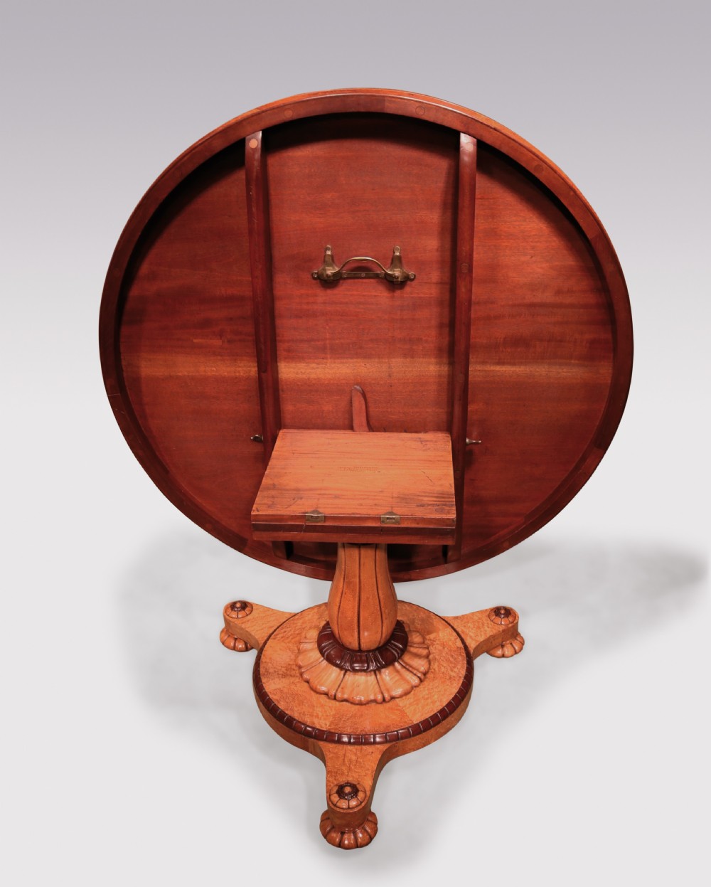 A circular mid-19th-century centre table crafted from birdseye maple featuring an inlaid decorative border, a carved baluster pedestal, and a platform base on carved feet. View IV