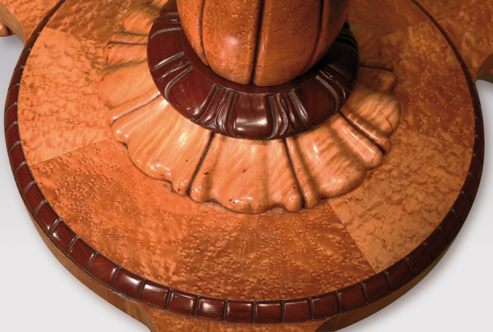 A circular mid-19th-century centre table crafted from birdseye maple featuring an inlaid decorative border, a carved baluster pedestal, and a platform base on carved feet. View VI