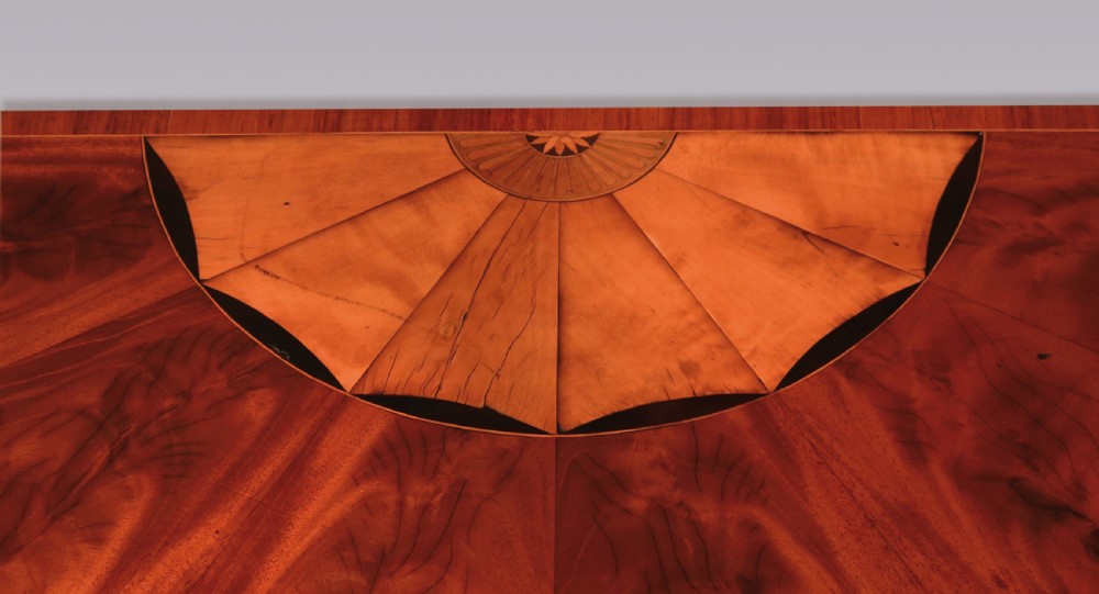 A late eighteenth-century semi-circular mahogany fold-over card table featuring fan-segmented veneer inlay on the top and fluted tapered legs. View II