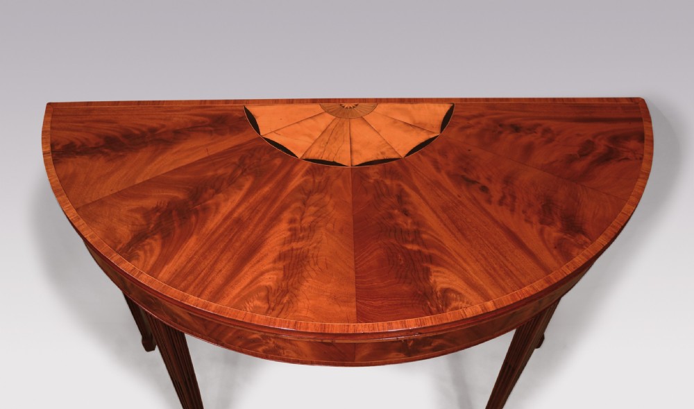 A late eighteenth-century semi-circular mahogany fold-over card table featuring fan-segmented veneer inlay on the top and fluted tapered legs. View III