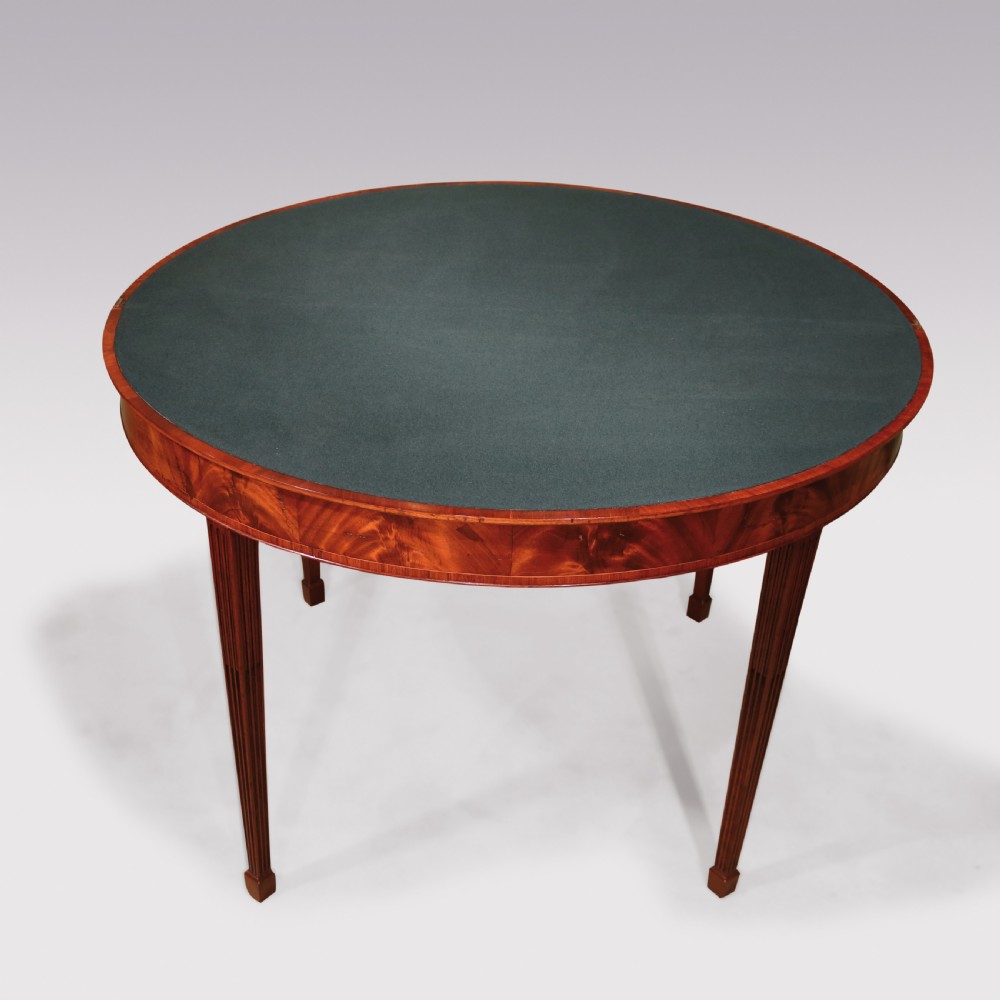A late eighteenth-century semi-circular mahogany fold-over card table featuring fan-segmented veneer inlay on the top and fluted tapered legs. View IV