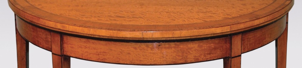 A demilune satinwood card table featuring inlaid crossbanding on the folding top and four square tapered legs. View III