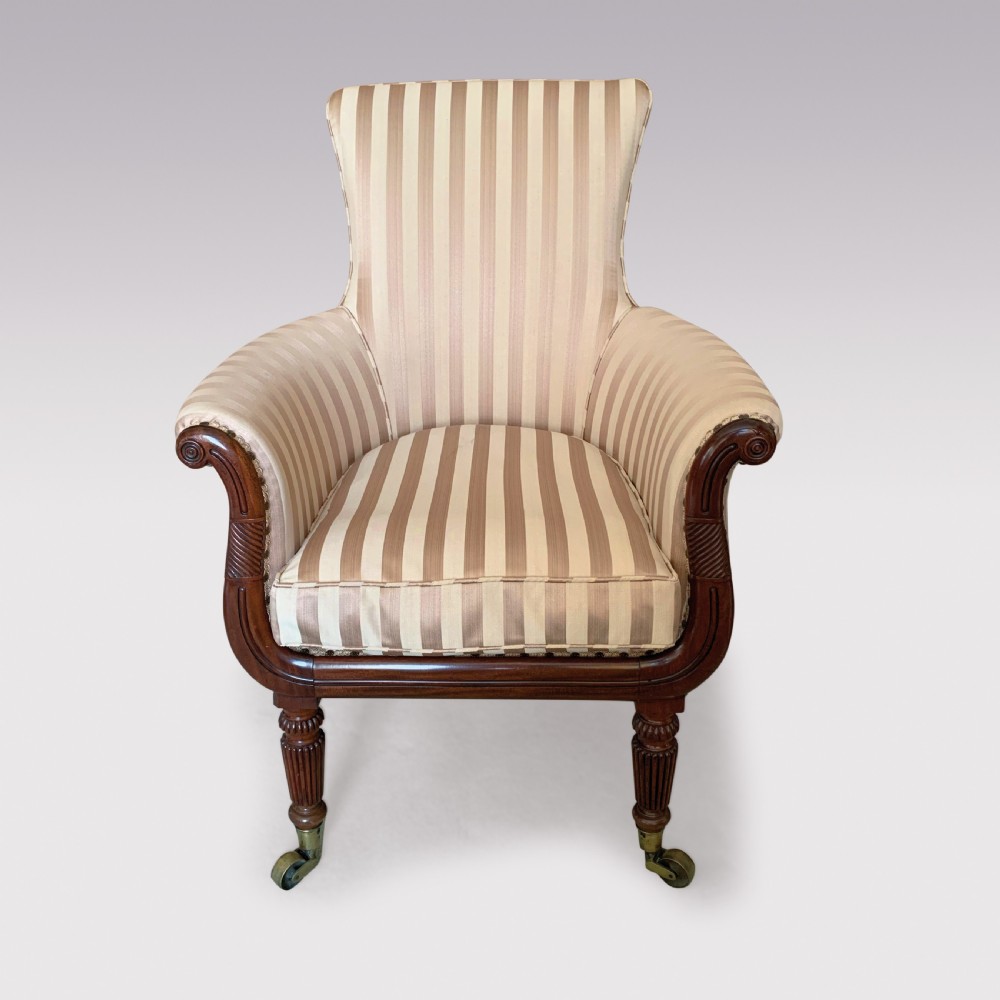 A 19th-century Regency mahogany tub chair featuring beige striped upholstery, scrolled lyre front arm supports, reeded legs, and brass castors. View II
