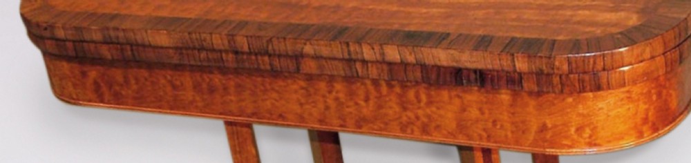 A Regency mahogany fold-over card table featuring decorative crossbanding, curved quadruped legs, and brass castors. View III