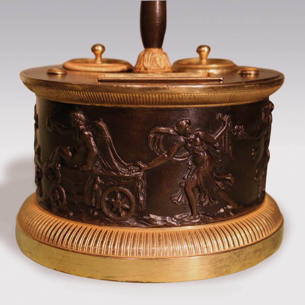 A 19th-century cylindrical French patinated bronze encrier featuring a classical relief frieze, gilded bronze borders, inkwell lids, and a central column handle. View III