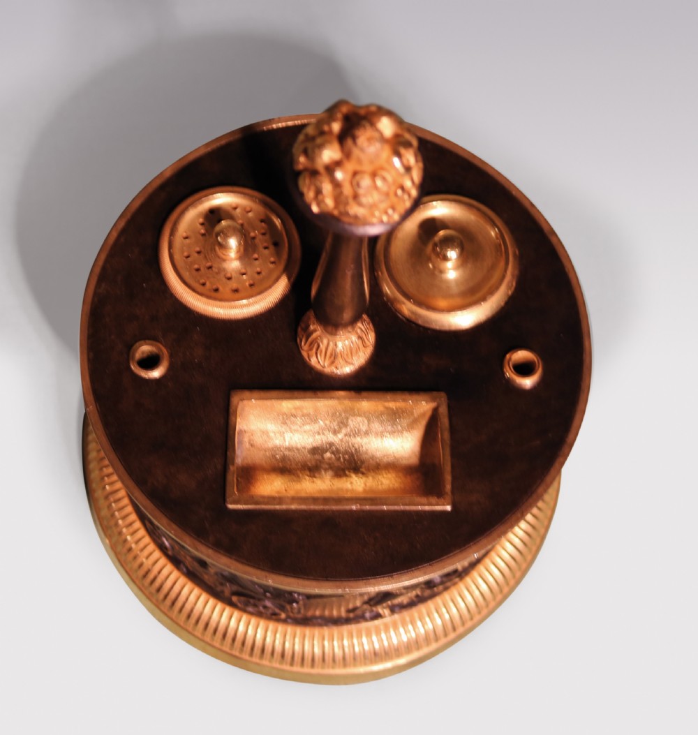 A 19th-century cylindrical French patinated bronze encrier featuring a classical relief frieze, gilded bronze borders, inkwell lids, and a central column handle. View IV