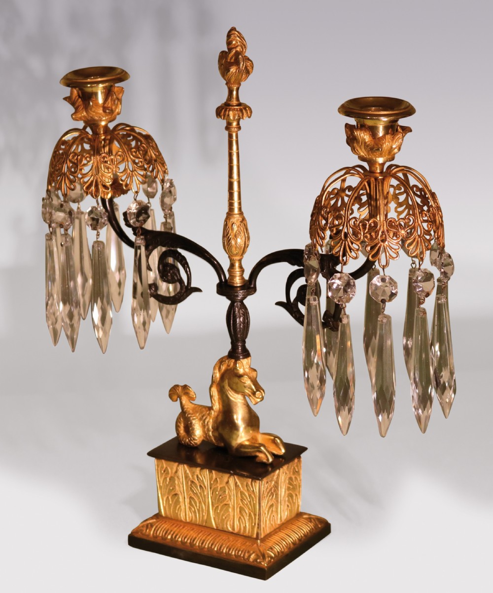 A set of three early 19th-century gilt bronze and patinated metal candlesticks featuring mythical seahorse mounts and hanging cut crystal drops. View II