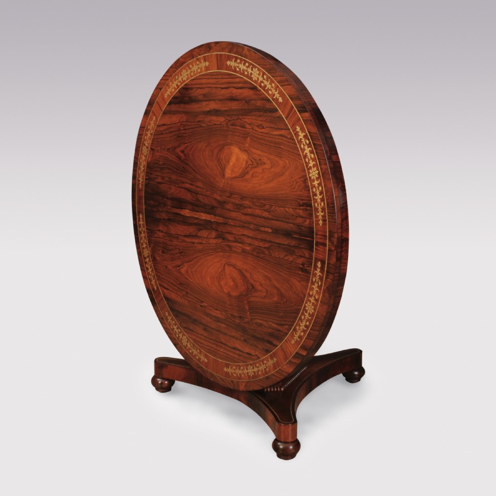 A circular Regency rosewood centre table featuring decorative brass inlay around the perimeter and supported by a pedestal on a triform base. View II