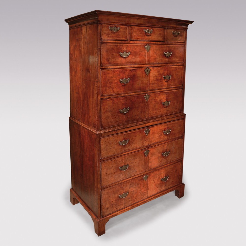 An 18th-century walnut chest on chest with two separate drawer sections, figured walnut veneers, bracket feet, and brass swing handles. View II