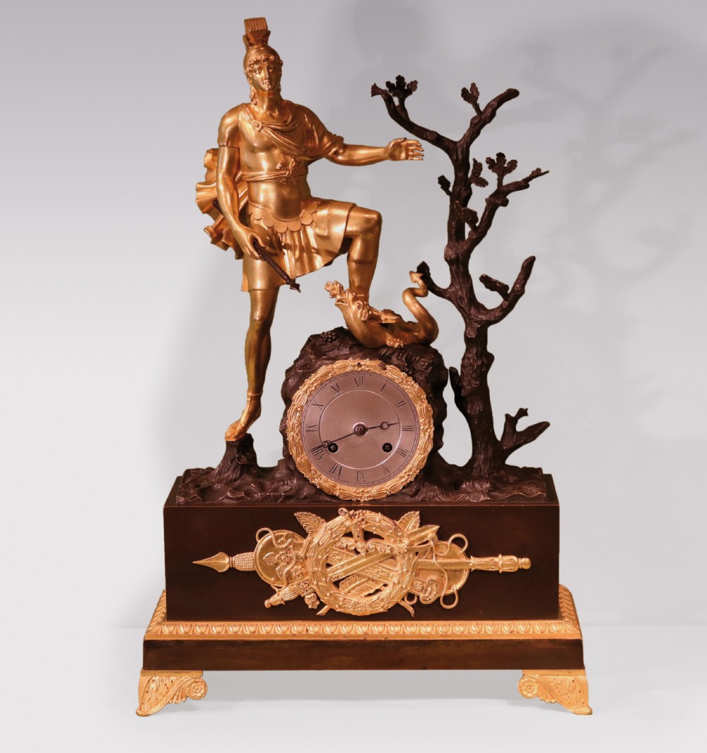 An early 19th-century French Empire clock crafted from gilt and patinated bronze, featuring a classical warrior figure standing beside a tree with a serpent atop a rectangular plinth.