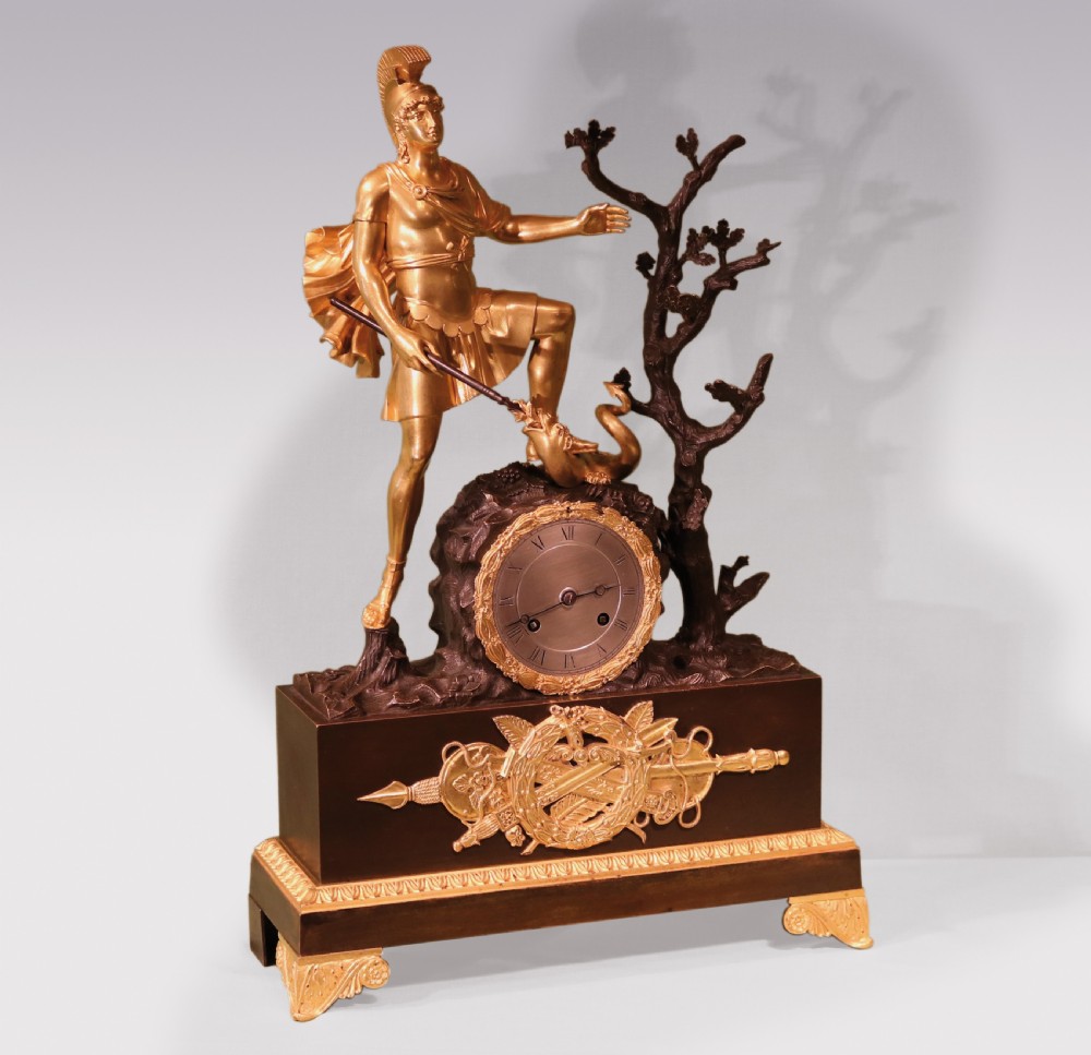 An early 19th-century French Empire clock crafted from gilt and patinated bronze, featuring a classical warrior figure standing beside a tree with a serpent atop a rectangular plinth. View II